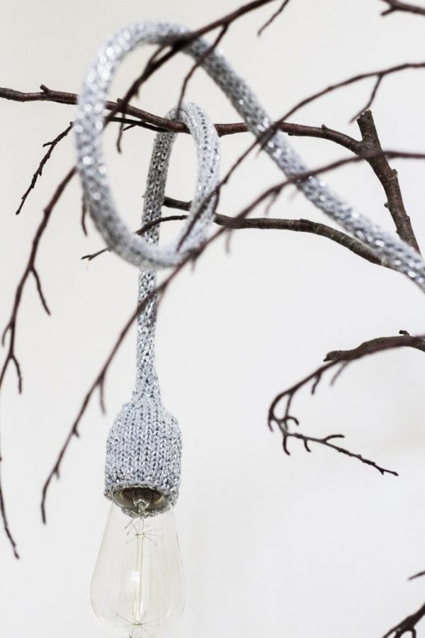 lampe baladeuse gris argenté disposée sur une branche d'arbre